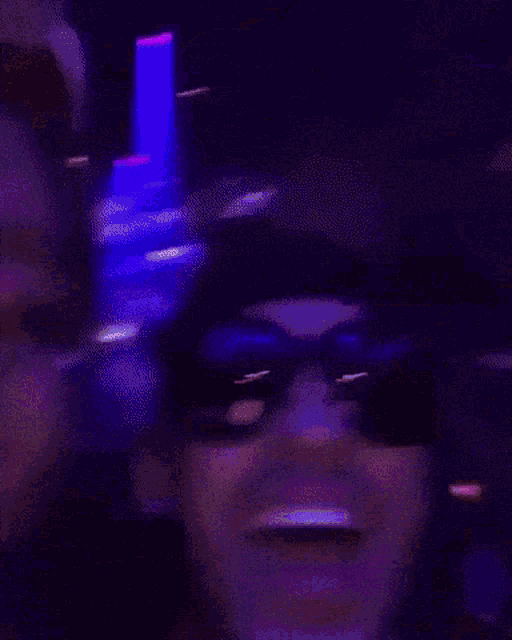 a man and a woman are posing for a picture in a dark room .