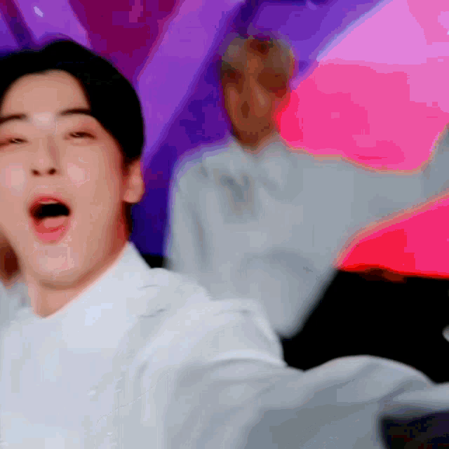 a man in a white shirt is making a funny face with his mouth open .