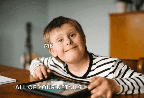 a boy with down syndrome is sitting at a table with a tablet and the words " all of your details " written above him