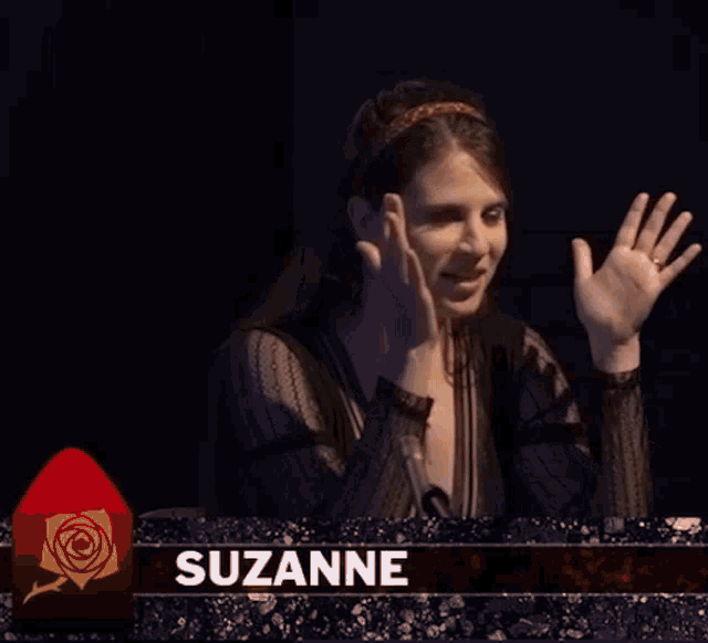 a woman is sitting at a table with the name suzanne on it .