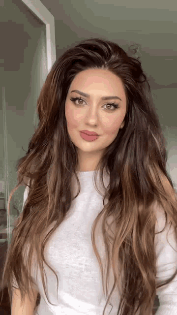 a woman with very long hair is wearing a white shirt