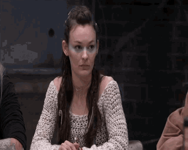 a woman with blue paint on her face is sitting at a table with a man .