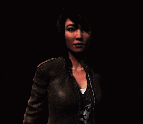 a woman wearing a brown leather jacket and a black shirt