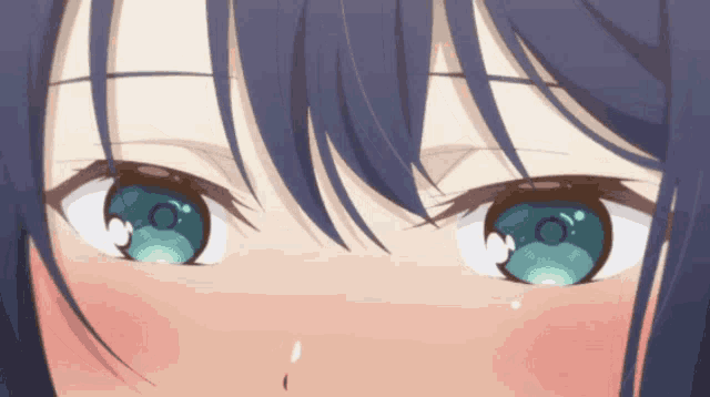 a close up of a girl 's blue eyes with a red cheek