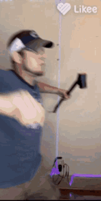 a man in a baseball cap is holding a hammer against a wall ..