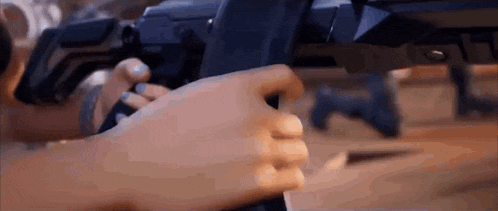 a person is holding a gun in their hand .