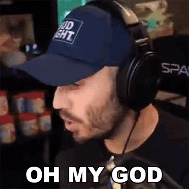 a man wearing headphones and a bud light hat says " oh my god "