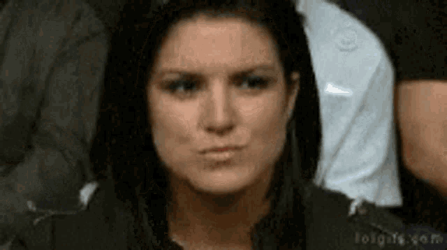 a woman is making a funny face in front of a crowd .