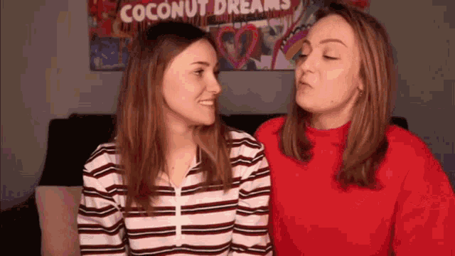 two women looking at each other in front of a coconut dreams poster