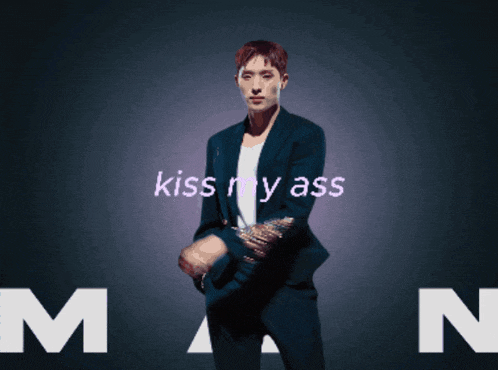 a man in a suit stands in front of a dark background that says kiss my ass man