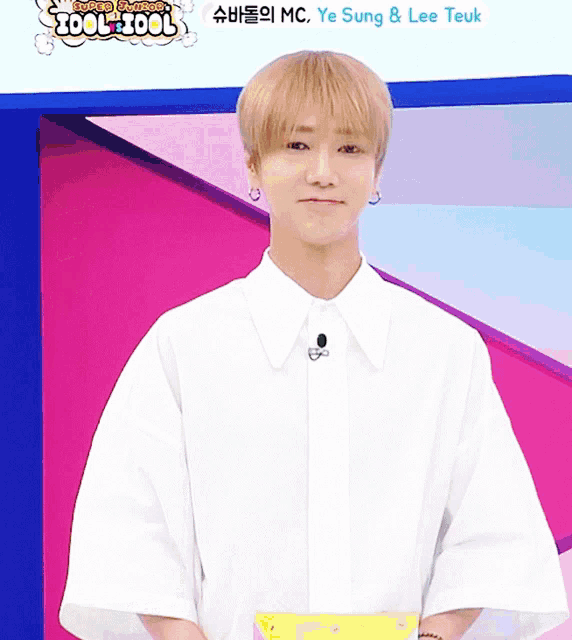 a young man in a white shirt stands in front of a sign that says zool-zool