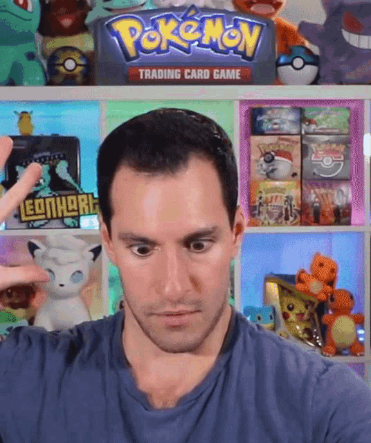 a man stands in front of a pokemon trading card game shelf