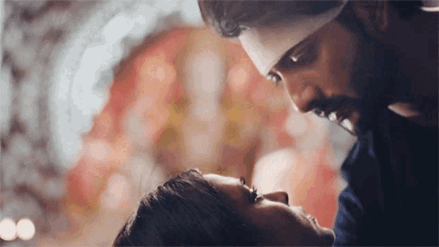 a man and a woman are looking at each other with their eyes closed