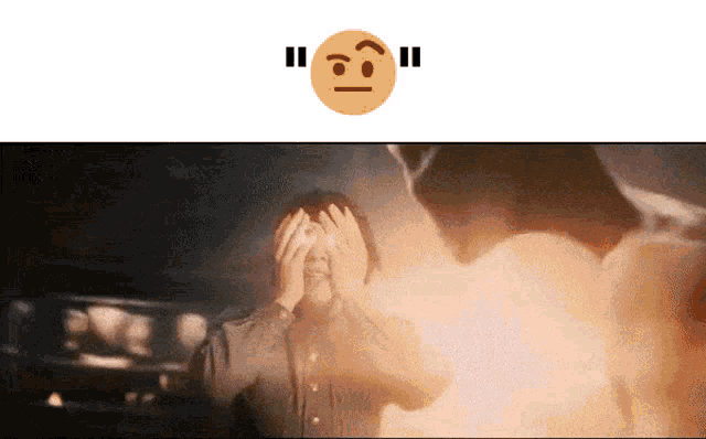 a man covering his face with his hands in front of a fire with a smiley face above him