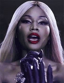 a close up of a woman holding a microphone with her mouth open .