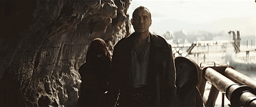 a man and a woman are standing next to each other in a dark room .