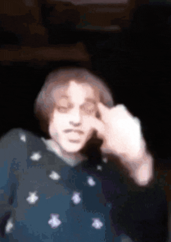 a blurry picture of a person making a face with their hand