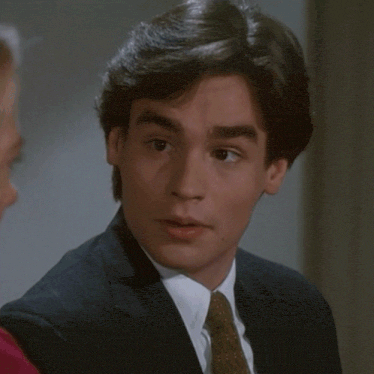 a man in a suit and tie is looking at a woman