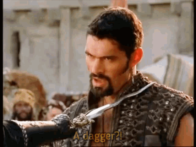 a man with a beard is holding a dagger and says a dagger
