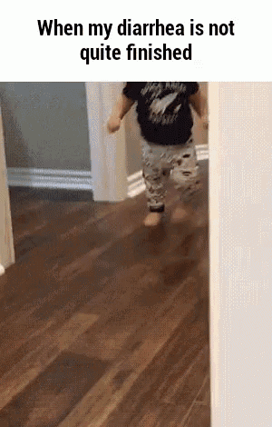 a baby is running on a wooden floor in a room .
