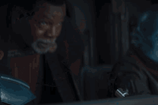 a man with a beard says " yes " in a dark room