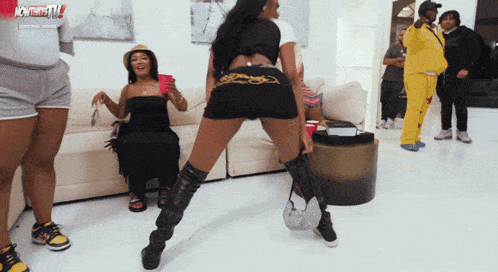a woman in a ed hardy shorts is dancing in a room