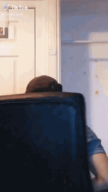 a man in a hat is sitting in front of a black suitcase with tik tok written on the bottom