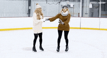 two women are holding hands while ice skating on a rink that has the number 30 on it