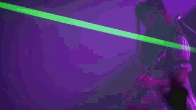 a woman playing a guitar in front of a crowd