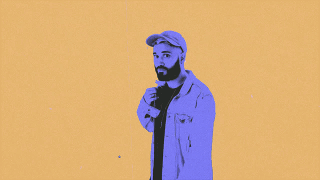 a man with a beard looks at the camera in a blue background