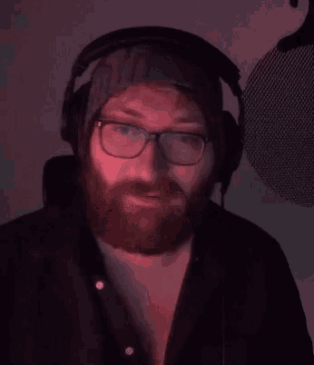 a man with glasses and a beard is wearing headphones