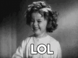 a black and white photo of a little girl laughing with the word lol written on her face .