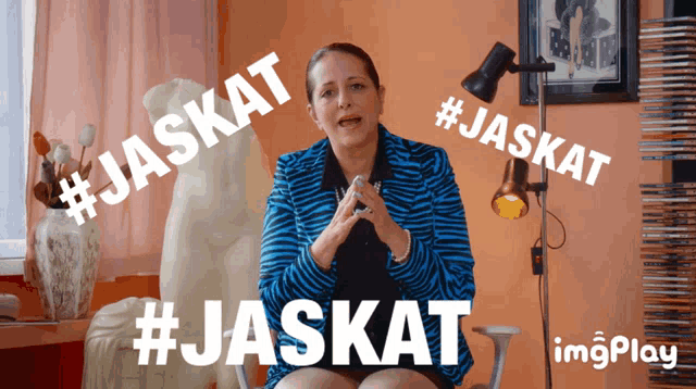 a woman in a zebra print jacket is sitting in front of a lamp with the words #jaskat written above her
