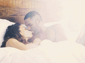 a man and a woman are kissing in a bed