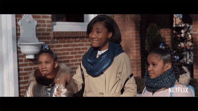 three girls are standing in front of a brick building with a netflix logo on the bottom