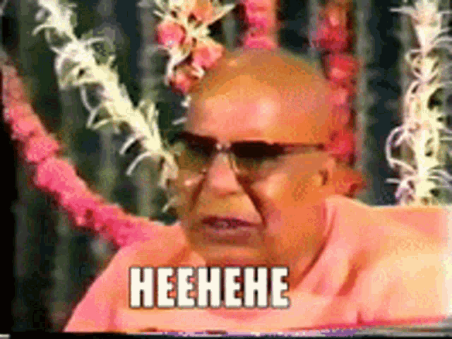 a bald man wearing sunglasses and a pink shirt says heehehe