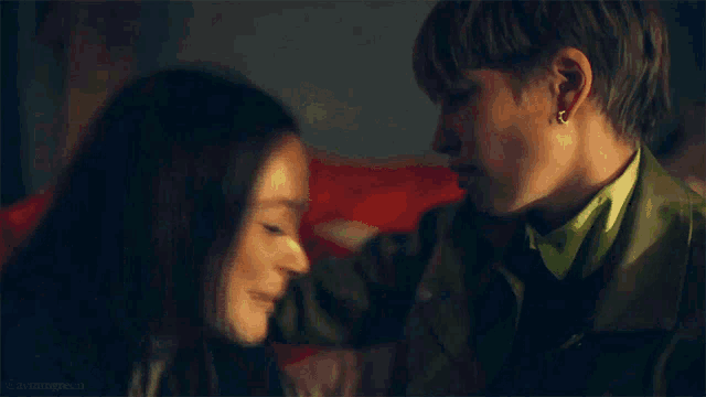 a man and a woman are looking into each other 's eyes and kissing .