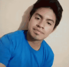 a man wearing a blue shirt is looking at the camera