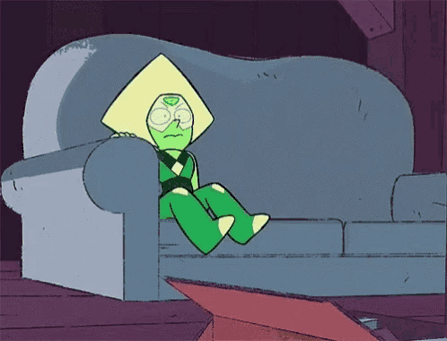 a green cartoon character is sitting on a couch in a room .