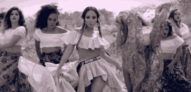 a woman wearing a supreme belt is surrounded by other women