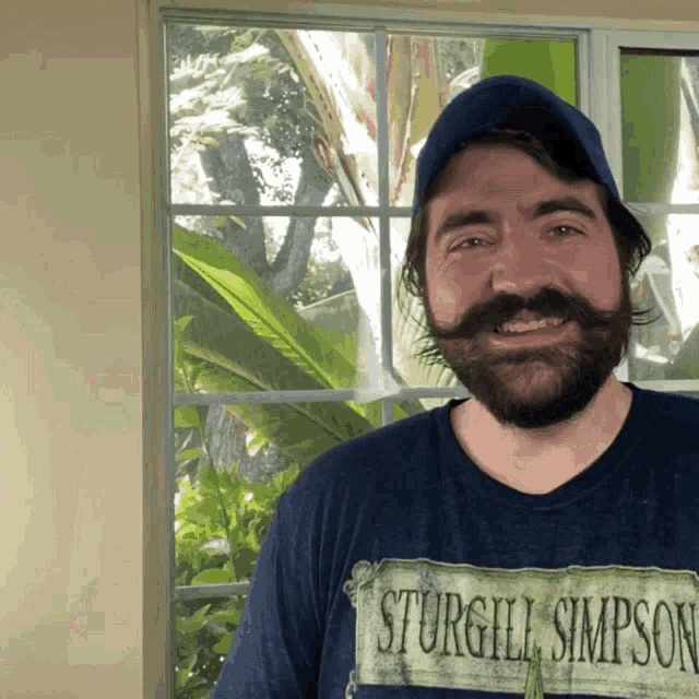 a man with a beard and mustache is wearing a sturgill simpson shirt
