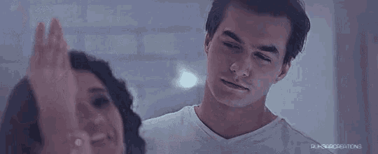 a man and a woman are looking at each other in the mirror .