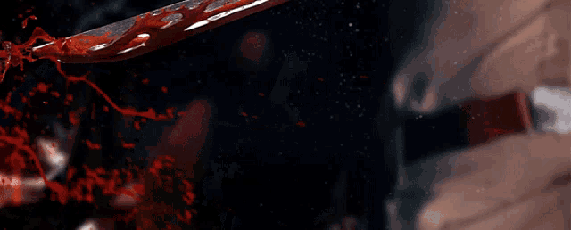 a bloody knife is being held by a person