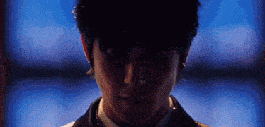 a close up of a man 's face with a blue background .