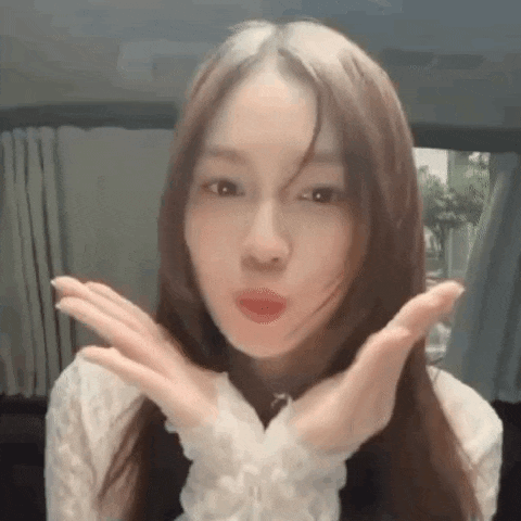a close up of a woman making a funny face with her hands in front of her face .