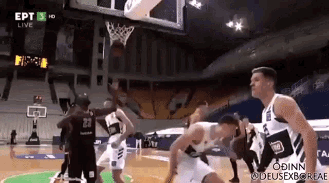 a group of basketball players are playing a game of basketball in a gym .