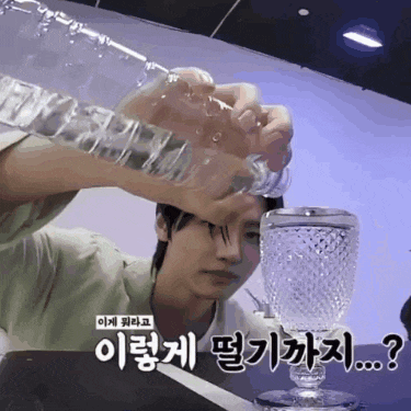 a man pouring water into a glass with korean writing on the bottom