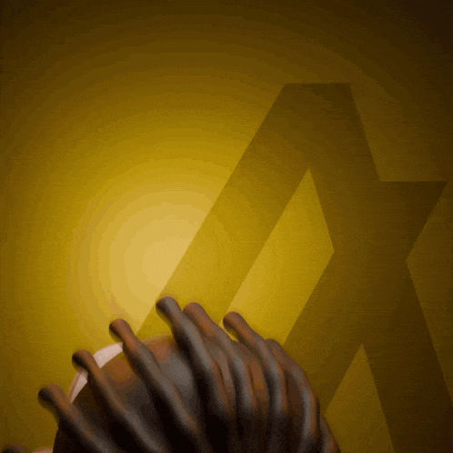 a person with dreadlocks holds a football in front of a yellow star