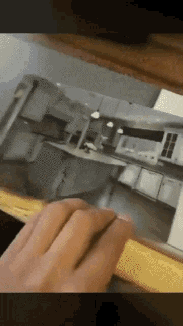 a person is touching a picture of a kitchen on a table