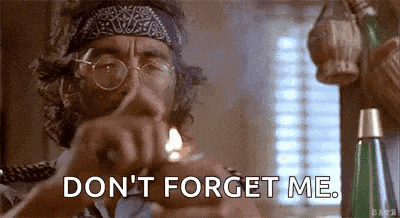 a man wearing glasses and a bandana is lighting a cigarette and says `` don 't forget me '' .